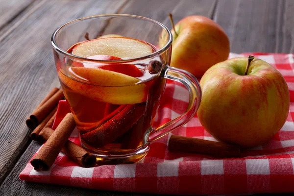Apple cider met kaneelstokjes en verse appelen op houten achtergrond — Stockfoto