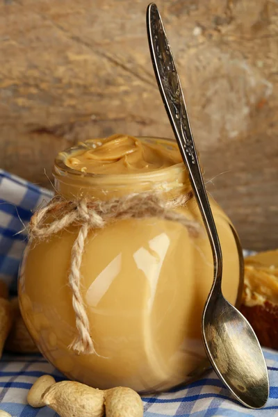 Beurre d'arachide frais en pot sur fond bois — Photo