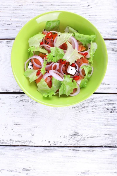 Frischer Fischsalat mit Gemüse auf Teller auf Holztisch in Großaufnahme — Stockfoto