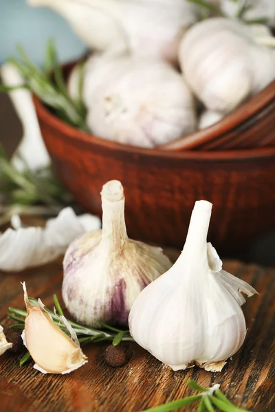 Rauwe knoflook en kruiden op houten tafel — Stockfoto