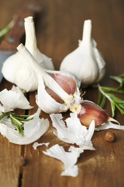 Rauwe knoflook en kruiden op houten tafel — Stockfoto