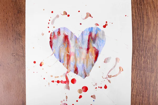 Пофарбоване серце на аркуші паперу на дерев'яному фоні столу — стокове фото
