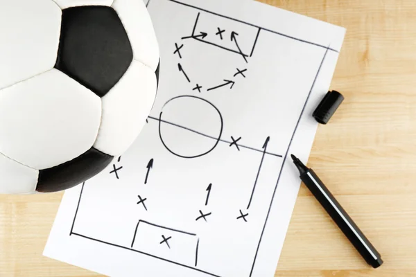 Schema gioco di calcio su foglio di carta e sfondo tavolo di legno — Foto Stock