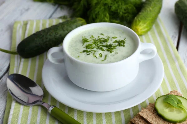 Gurkensuppe in Schüssel auf farbigem Holztischhintergrund — Stockfoto