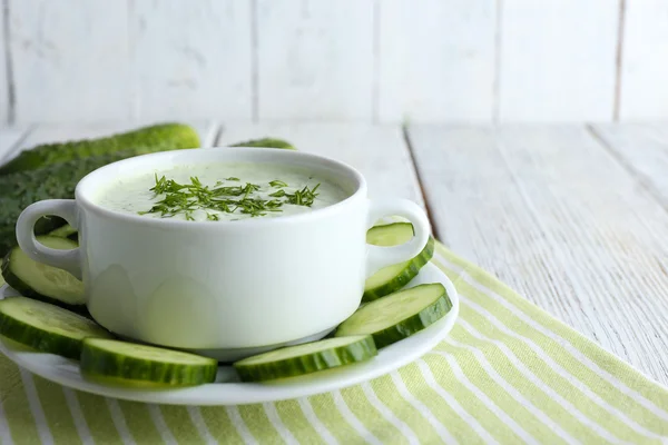 Cucumber soup in bowl on color wooden table background — Stock Photo, Image
