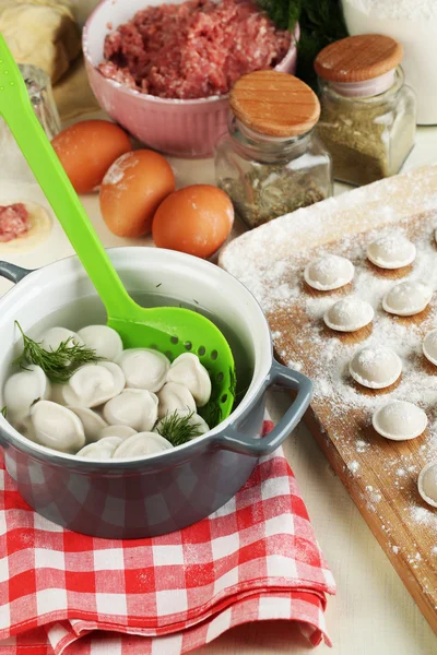 Raw and cooked dumplings close-up in kitchen — Stock Photo, Image