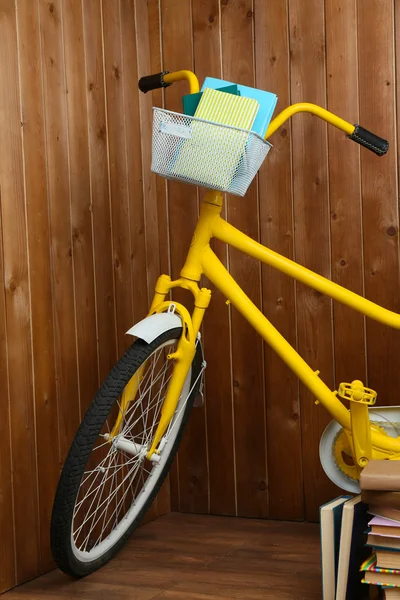 Bicicletta con libri su fondo parete in legno — Foto Stock