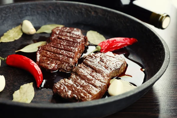Biefstuk in koekenpan op tafel close-up — Stockfoto