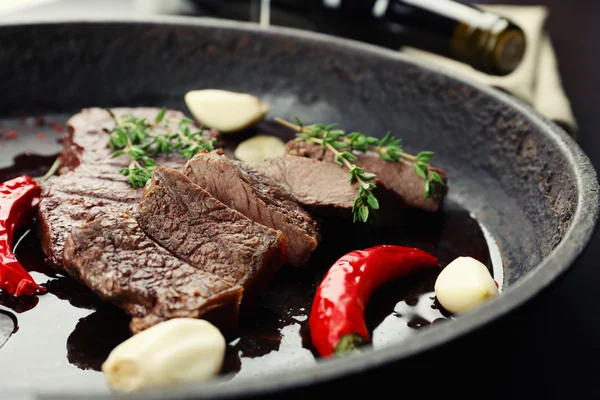 Steak in frying pan on table close up — Stock Photo, Image