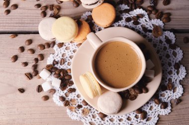 Yumuşak renkli kurabiye ve kahve kupa ahşap masa arka plan üzerinde