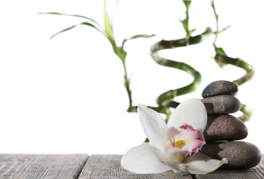 Natürmort spa taş ahşap plakalar yüzeyi üzerinde beyaz izole bambu sopayla