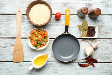 Gıda katkı maddeleri ve ahşap arka plan üzerinde yemek pişirmek için mutfak gereçleri