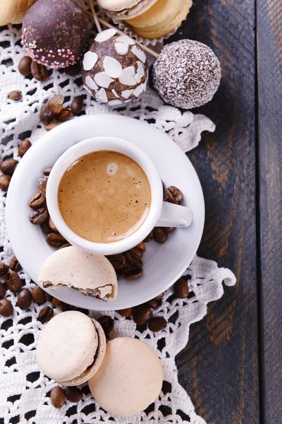 Makaroni yang lembut dan berwarna-warni dan kopi dalam cangkir pada latar belakang meja kayu — Stok Foto