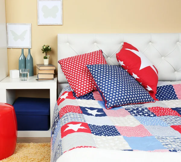 Moderno interior colorido dormitorio con cama y mesita de noche, con detalles de diseño en fondo de pared de luz — Foto de Stock