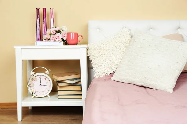 Intérieur moderne et coloré de la chambre avec lit et table de chevet, avec des détails de conception sur fond de mur clair — Photo