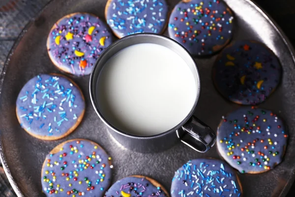 Biscoitos vitrificados em bandeja de metal com caneca de leite em pranchas de madeira rústica fundo — Fotografia de Stock