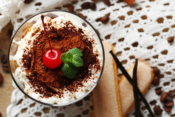 Sabroso postre tiramisú en vaso, en servilleta, sobre fondo de madera — Foto de Stock