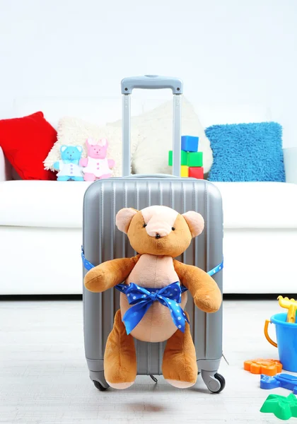 Suitcase with teddy bear and child toys in room on white sofa background — Stock Photo, Image