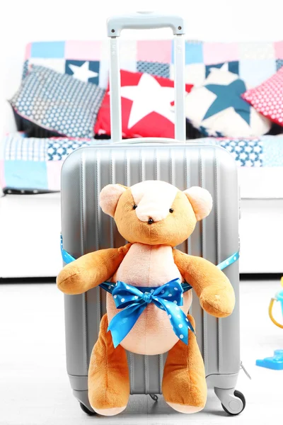 Suitcase with teddy bear and child toys in room on white sofa background — Stock Photo, Image