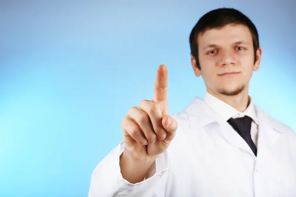 Doctor working with virtual screen on blue background — Stock Photo, Image