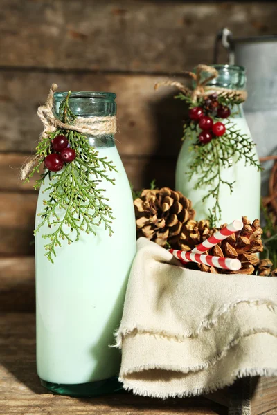 Bouteilles de lait frais au décor naturel, sur fond de bois — Photo