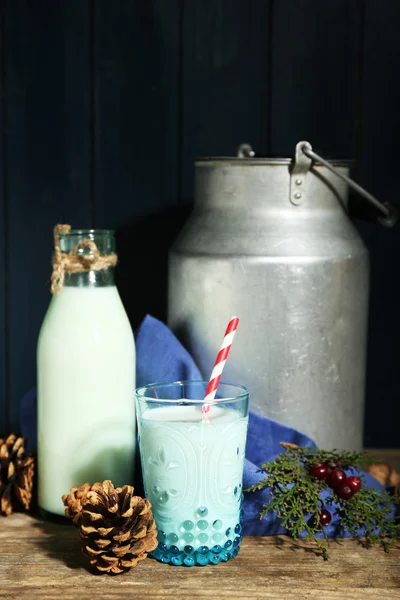 Čerstvé mléko s přírodním dekorem, na dřevěné pozadí — Stock fotografie