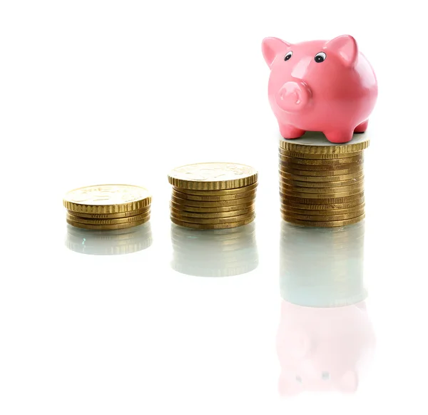 Banco porquinho em pé na pilha de moedas isoladas em branco — Fotografia de Stock