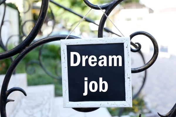 Signboard com texto Dream Job sobre ele pendurado em cerca de metal — Fotografia de Stock