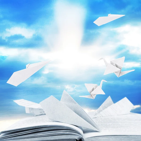 Origami vliegtuigen op boek over sky bakground — Stockfoto