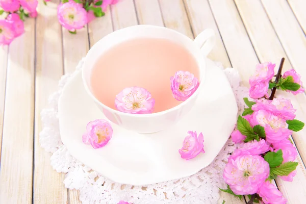 Fleurs de fruits avec une tasse de thé — Photo