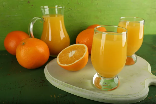 緑色の背景上のスライスでのオレンジ ジュースのガラス — ストック写真