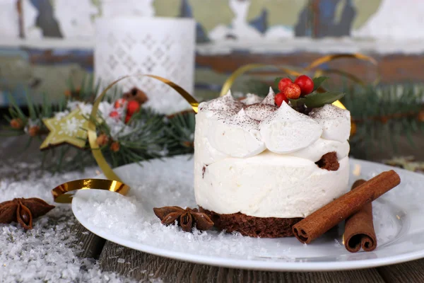 Deliziosa torta sul piatto con cannella e anice stellato sullo sfondo della decorazione natalizia — Foto Stock