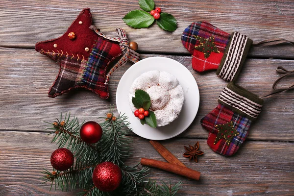 Leckeren Kuchen auf Untertasse mit Stechpalme und Beere auf Weihnachtsdekoration und Holz Hintergrund — Stockfoto