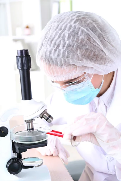 Cientista feminina usando microscópio em laboratório — Fotografia de Stock