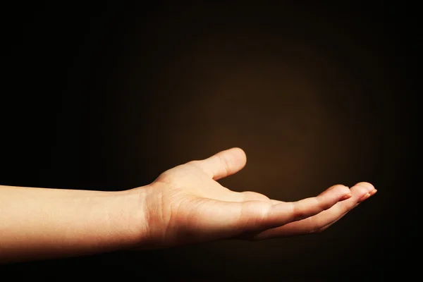 Female hand on dark background — Stock Photo, Image