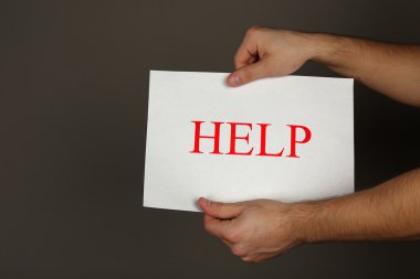 Kağıdın yardımıyla koyu arka plan üzerinde erkek elinde kayıt