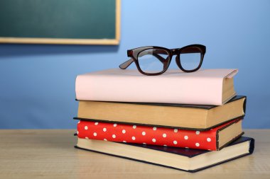 Gözlüklü kitap yığını