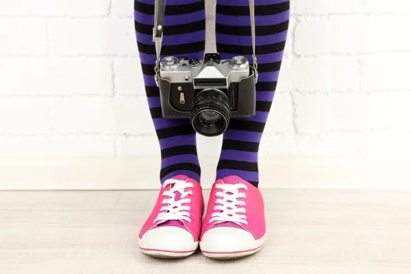 Menina em tênis com câmera retro — Fotografia de Stock