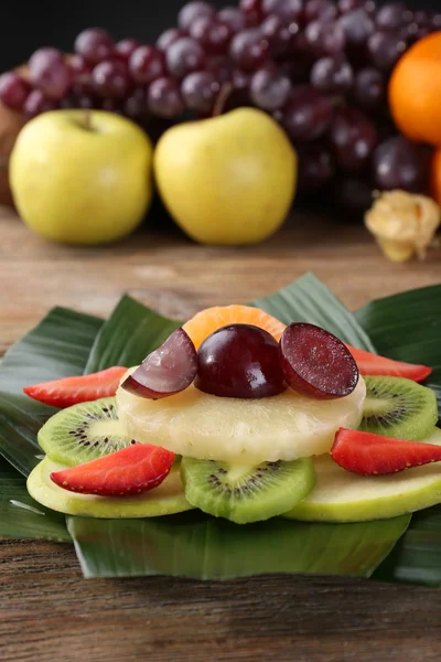 Fruit dessert op groene blad op tafel — Stockfoto