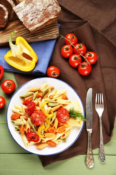Těstovinový salát s paprikou, mrkev a rajčata na dřevěný stůl pozadí — Stock fotografie