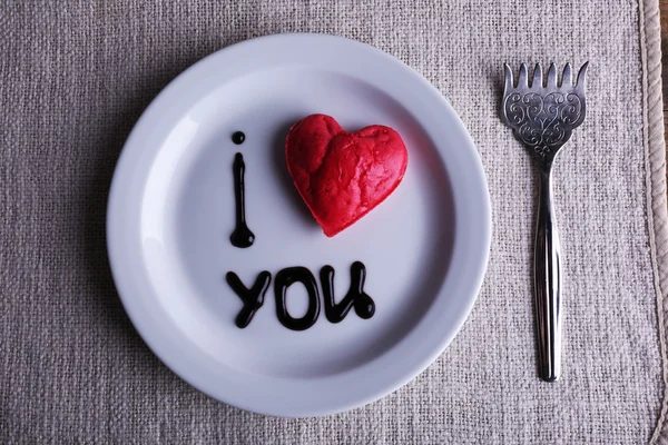 Galleta en forma de corazón en plato con inscripción I Love You, sobre fondo de servilleta —  Fotos de Stock