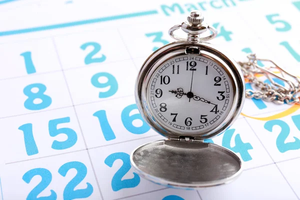カレンダーの背景にシルバー ポケット時計 — ストック写真