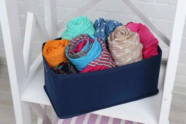 Bufandas en caja textil en estante — Foto de Stock