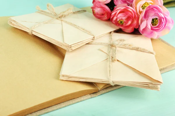 Old letters and book with flowers on wooden background — Stock Photo, Image