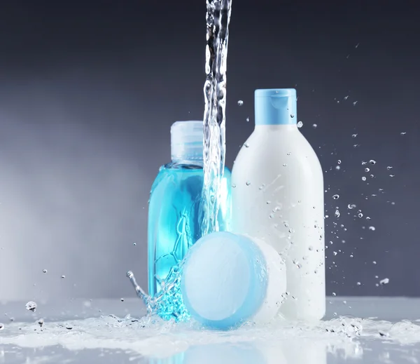 Cosmetische producten in water spatten — Stockfoto