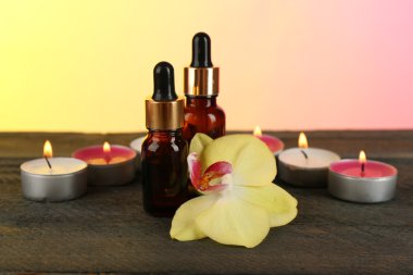 Aromatik yağlar ve mum parlak zemin üzerine masada şişeler