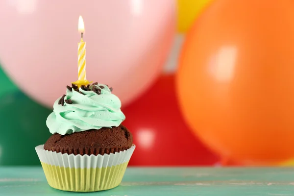 Delicioso cupcake de cumpleaños en la mesa sobre fondo brillante — Foto de Stock