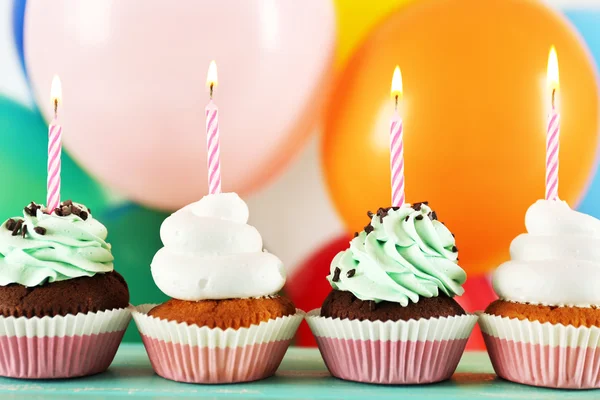 Deliciosos cupcakes de cumpleaños en la mesa sobre un fondo brillante —  Fotos de Stock