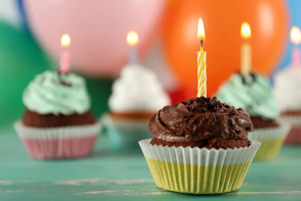 Deliciosos cupcakes de cumpleaños en la mesa sobre un fondo brillante — Foto de Stock