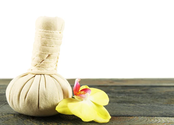 Bolsa de massagem à base de plantas com orquídea na mesa sobre fundo claro — Fotografia de Stock